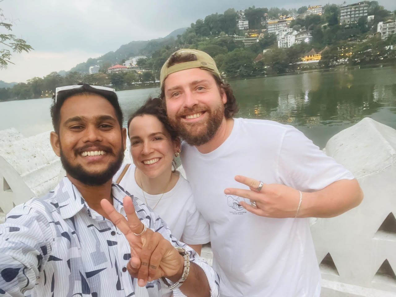 Travellers with their Ceylon Trusted Tours guide beside Kandy Lake at dusk